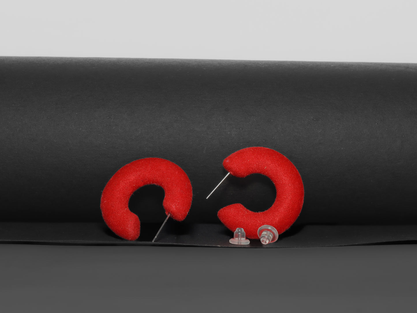Red flocked c-shaped hoop earrings.