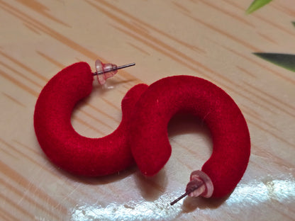 Red flocked c-shaped hoop earrings.