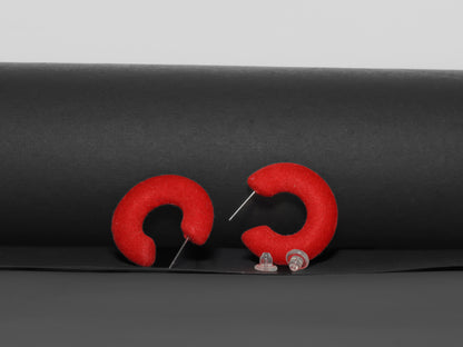 Red flocked c-shaped hoop earrings.